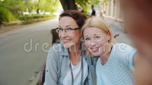 快乐女性朋友在户外咖啡厅自拍摆姿势玩得开心的肖像视频的预览图