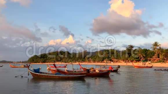泰国KohLanta海滩上传统的长尾小船拍摄的日落照片视频的预览图