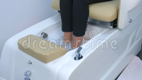 女人正泡着脚坐在浴盆里坐在修脚椅上双腿特写视频的预览图