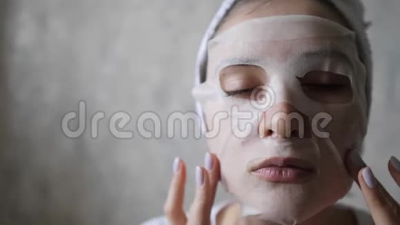 一位年轻的白种人妇女的肖像她脸上戴着保湿面具头上戴着毛巾健康生活方式视频的预览图