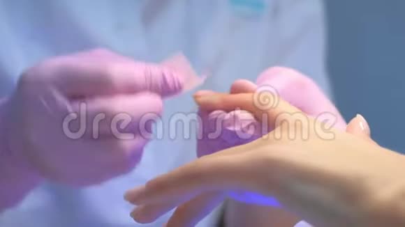 在UV中聚合后Manicurist大师用无棉抹布擦拭指甲视频的预览图