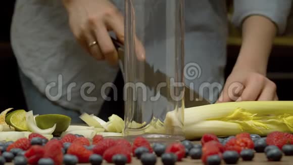 女人把切碎的芹菜放进搅拌机里视频的预览图