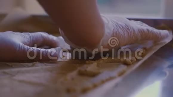 一个人在面团里切一块长方形饼干特写侧景视频的预览图