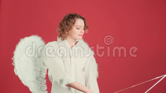 情人节的人的概念天使女孩带着弓箭越过红色背景带弓箭的天使女孩视频的预览图