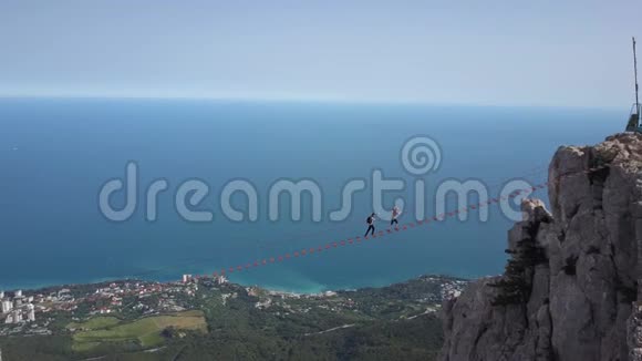 在克里米亚著名的艾佩特里山峰上游客沿着极端的桥步行的空中镜头视频的预览图