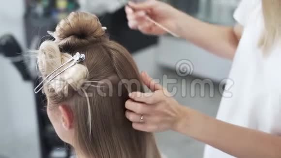 特写理发师用刷子梳客户的金发视频的预览图