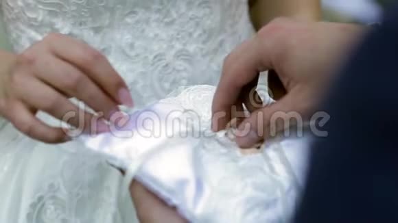 新郎把结婚戒指从垫子上拿出来放在新娘手指上视频的预览图