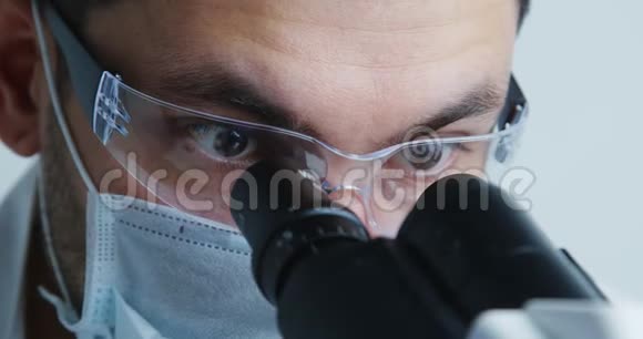 年轻的科学家在显微镜下观察视频的预览图