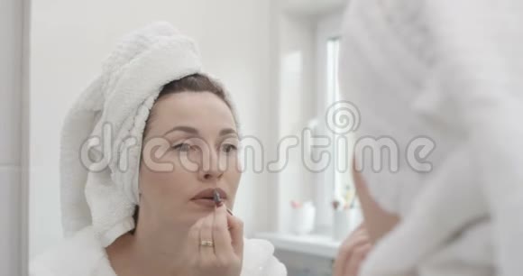 女人化妆做轮廓用唇笔拍摄红色史诗视频的预览图