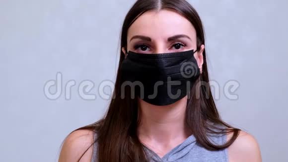 戴黑色防护面罩的女性患者看着镜头卫生概念防止细菌传播视频的预览图