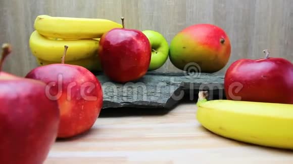 厨房桌子上的新鲜水果和石头纹理苹果芒果和香蕉水果视频的预览图