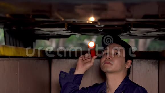 男机修工拿着手电筒检查汽车问题视频的预览图