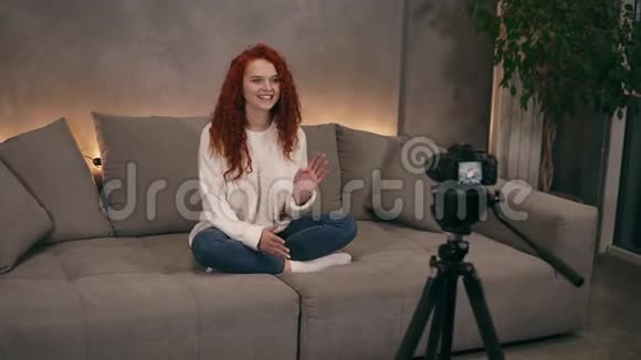 迷人的卷曲红头发的年轻女孩vlogger正在互联网上为在线博客录制视频镜头前讲话视频的预览图
