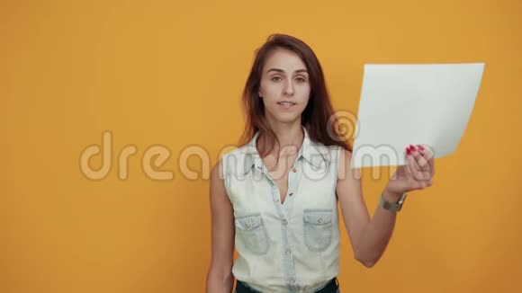 漂亮的女人穿着蓝色牛仔衬衫手里拿着白纸微笑着视频的预览图