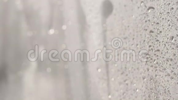 淋浴时玻璃上的水滴浴室淋浴间玻璃墙上的水流没人运动4k视频视频的预览图
