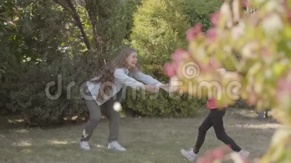 小白种人女孩跑到她美丽的微笑母亲在公园一头长着卷发的女人视频的预览图