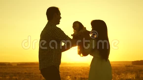 一家人带着孩子在夕阳下的田野里父亲女儿和母亲正在球场上玩耍妈妈和爸爸视频的预览图
