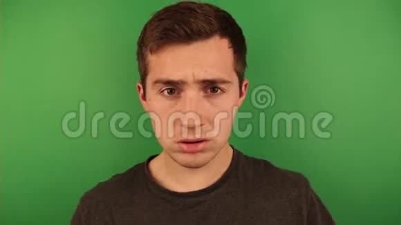 一个男人在绿色背景下对着镜头做鬼脸视频的预览图