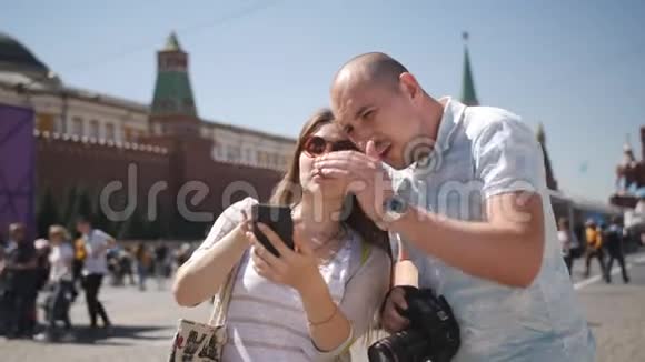 幸福情侣游客漫步在莫斯科红色广场欣赏并拍照留念视频的预览图