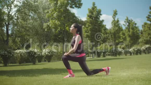 健身妇女在公园草坪上做跳跃运动视频的预览图