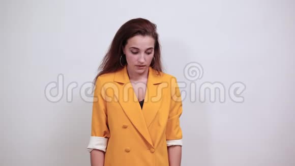 穿着黄色夹克的年轻女子手捂着嘴满脸震惊视频的预览图