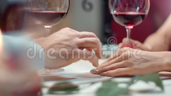 在浪漫的晚餐约会中亲密的男性手触摸女性手臂感受爱情4k龙红相机视频的预览图