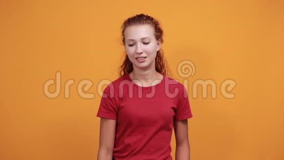 穿着红衬衫的漂亮年轻女士表现出良好的姿态微笑笑视频的预览图