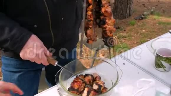 一个人在玻璃菜中把肉从扦子里取出户外烹饪视频的预览图