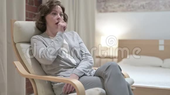 生病的老妇人在沙发上咳嗽视频的预览图