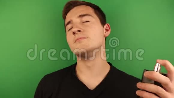 这个人用香水在自己身上最后一次把它倒进他的嘴里在绿色的背景上视频的预览图