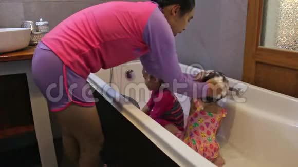 母亲在度假村的浴缸里给女儿洗澡视频的预览图