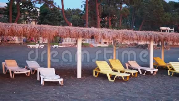 夏天阳光明媚海岸荒凉的海滩上有阳光海边的海滩上有一排空的甲板椅废弃地t视频的预览图