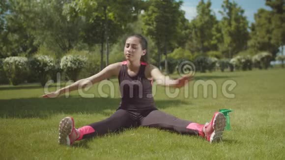 亚洲女人在公园草坪上锻炼肌肉视频的预览图