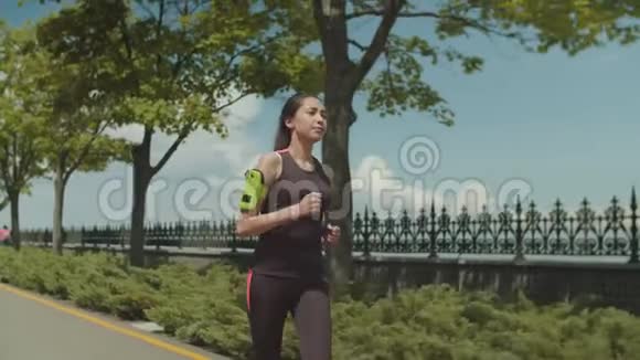 健身亚洲女子晨跑公园车道视频的预览图