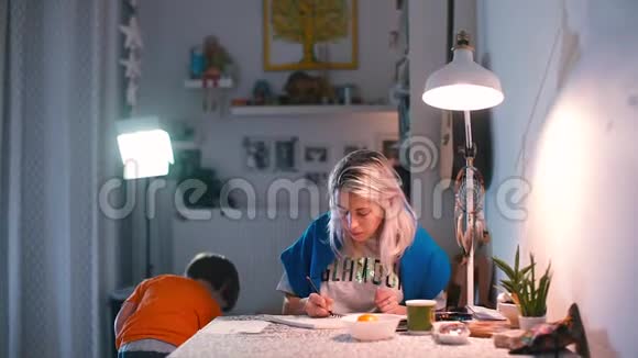 妈妈和她的儿子一起在餐桌上画画视频的预览图