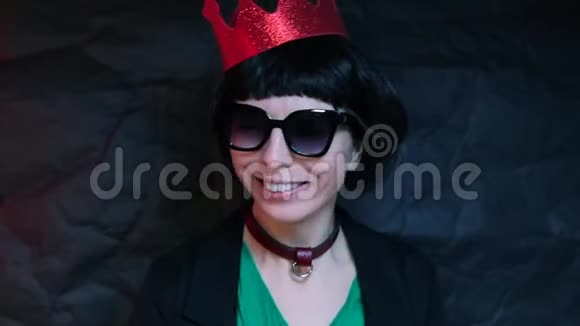 带眼镜的快乐女孩黑色背景上的红色皇冠视频的预览图