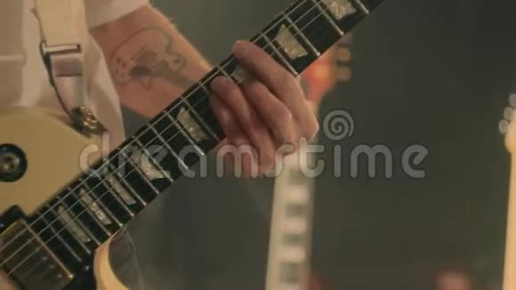 吉他手的特写他的手在舞台上弹奏白色电吉他视频的预览图
