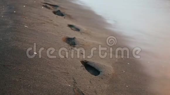 海浪冲走了日落时沙滩上的痕迹视频的预览图