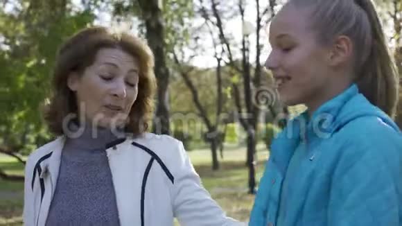 年轻貌美的白种人奶奶和她十几岁的孙女穿着休闲装走在视频的预览图