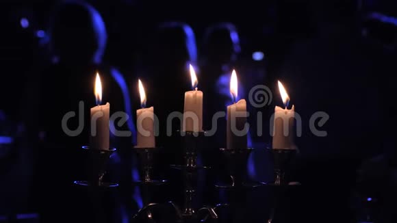在夜总会里在烛台上点燃蜡烛在跳舞的人附近视频的预览图