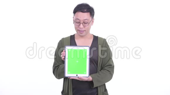 戴眼镜的快乐日本男人一边看数码平板电脑一边思考视频的预览图