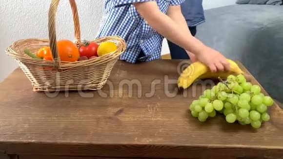 孩子们从木桌上的柳条篮子里分发水果和蔬菜孩子们在商店里玩游戏购物的概念视频的预览图