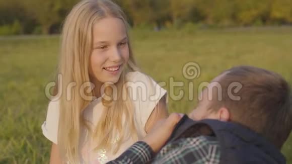 一个年轻的金发女孩和她父亲有感情地交谈一家人一起度过秋日视频的预览图