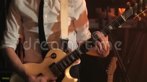 穿着白色衬衫和黑色领带的吉他手轻轻地用电吉他弹奏和弦视频的预览图