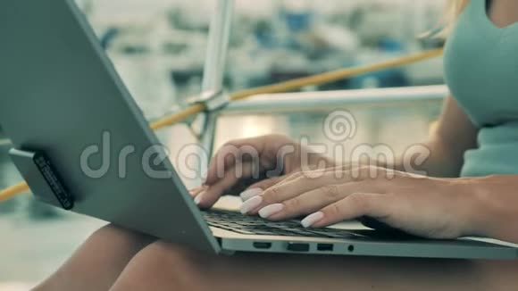 靠近女人她的手在靠近水的笔记本电脑上打字视频的预览图
