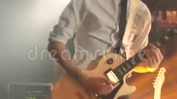 舞台上有吉他摇滚的年轻人背景上有温暖的闪光灯视频的预览图