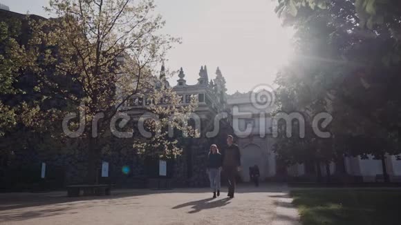 爱的一对夫妇在傍晚的阳光下手牵着手走在宫殿公园里视频的预览图