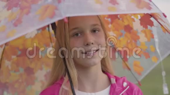 一位带着金色头发浅棕色眼睛的白种人女孩身穿粉色夹克手里拿着一件漂亮的外套视频的预览图