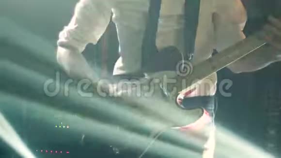穿着白色衬衫和黑色领带的吉他手弹着电视吉他震撼舞台视频的预览图