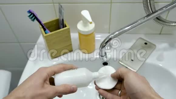 男人手使用特殊的液体消毒他们的手和电话在浴室第一人称观点视频的预览图
